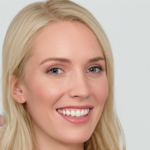 Joyful white young-adult female with long  blond hair and blue eyes