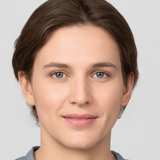 Joyful white young-adult female with short  brown hair and grey eyes