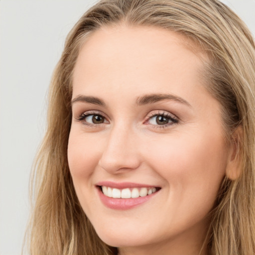 Joyful white young-adult female with long  brown hair and brown eyes