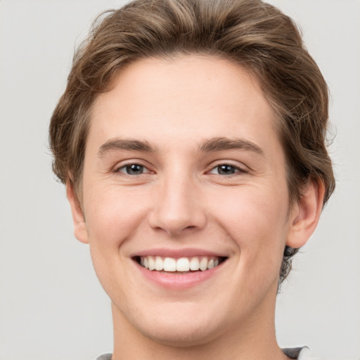 Joyful white young-adult female with short  brown hair and grey eyes