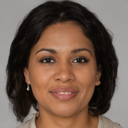 Joyful black adult female with medium  brown hair and brown eyes