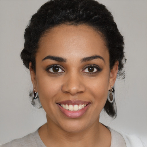 Joyful black young-adult female with medium  black hair and brown eyes
