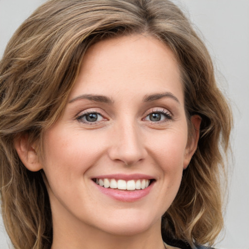 Joyful white young-adult female with long  brown hair and green eyes