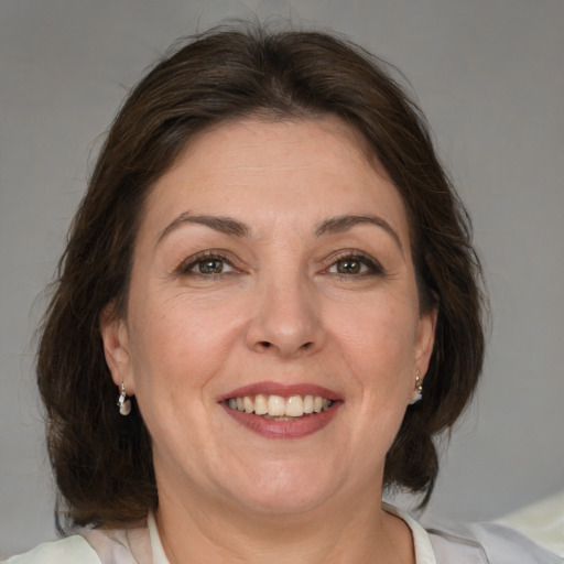 Joyful white adult female with medium  brown hair and brown eyes