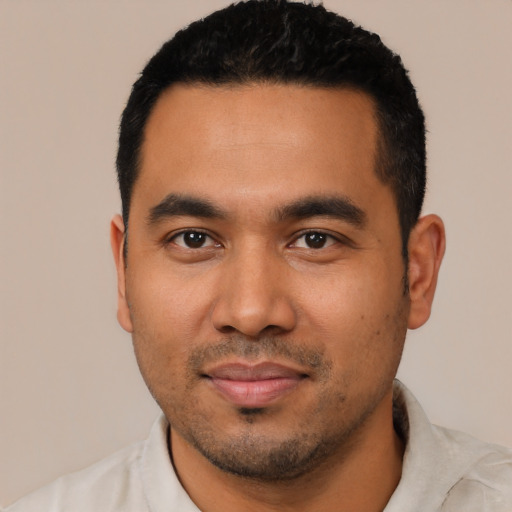 Joyful latino young-adult male with short  black hair and brown eyes