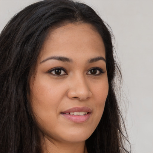 Joyful latino young-adult female with long  brown hair and brown eyes