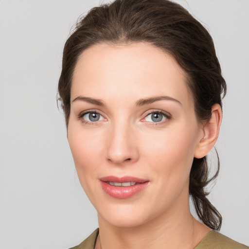 Joyful white young-adult female with medium  brown hair and grey eyes