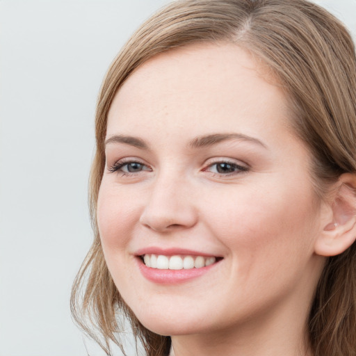 Joyful white young-adult female with long  brown hair and blue eyes