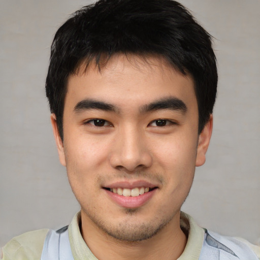 Joyful asian young-adult male with short  black hair and brown eyes
