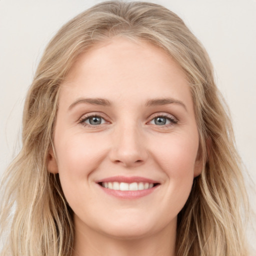 Joyful white young-adult female with long  brown hair and blue eyes