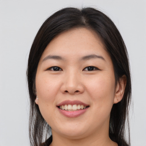 Joyful asian young-adult female with long  brown hair and brown eyes