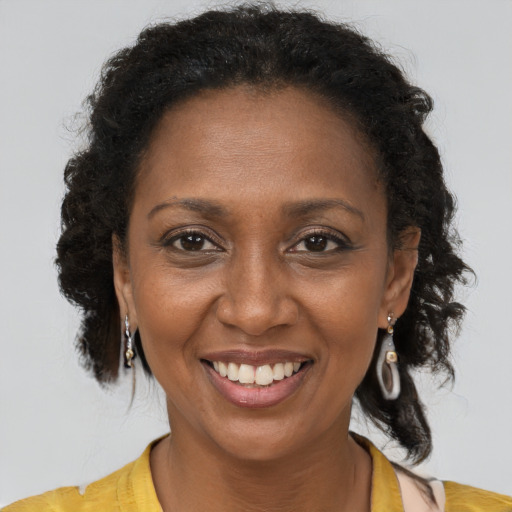 Joyful black adult female with short  brown hair and brown eyes