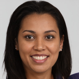 Joyful latino young-adult female with long  brown hair and brown eyes