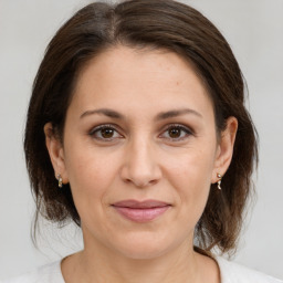 Joyful white adult female with medium  brown hair and brown eyes