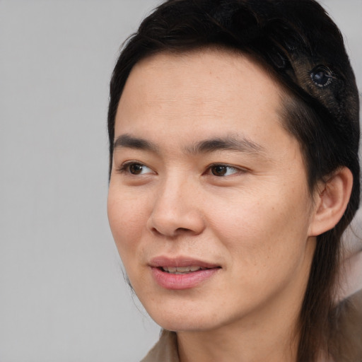 Joyful asian young-adult male with long  brown hair and brown eyes