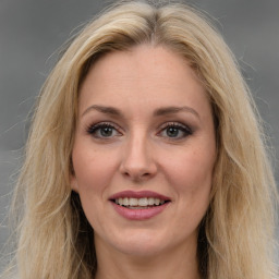 Joyful white adult female with long  brown hair and grey eyes