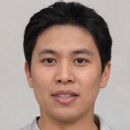 Joyful asian young-adult male with short  black hair and brown eyes