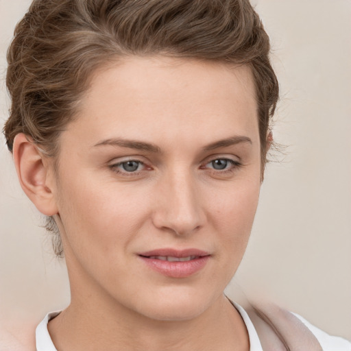 Joyful white young-adult female with short  brown hair and grey eyes