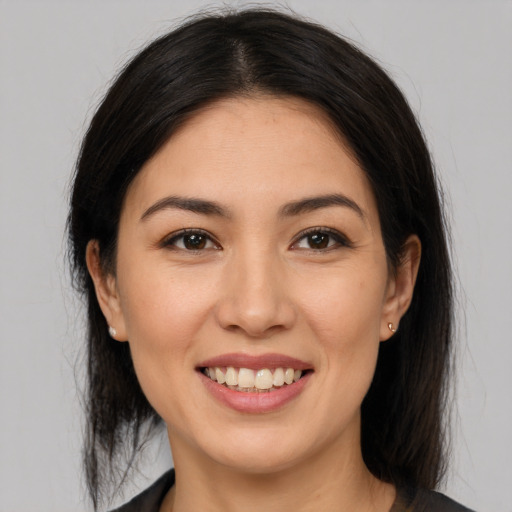 Joyful latino young-adult female with medium  brown hair and brown eyes