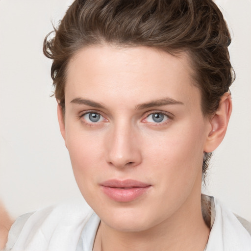 Joyful white young-adult female with short  brown hair and blue eyes