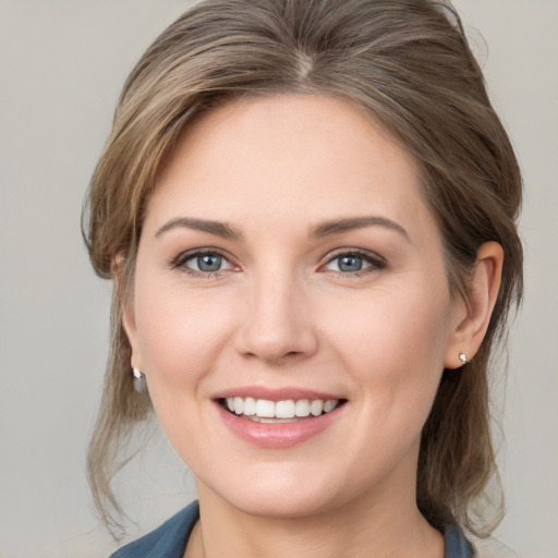 Joyful white young-adult female with medium  brown hair and grey eyes