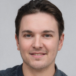 Joyful white young-adult male with short  brown hair and grey eyes