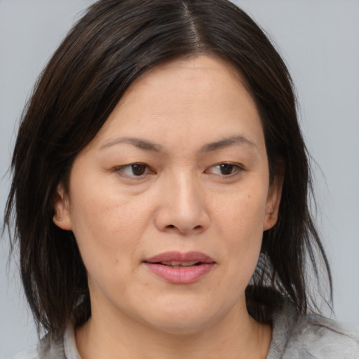 Joyful asian adult female with medium  brown hair and brown eyes