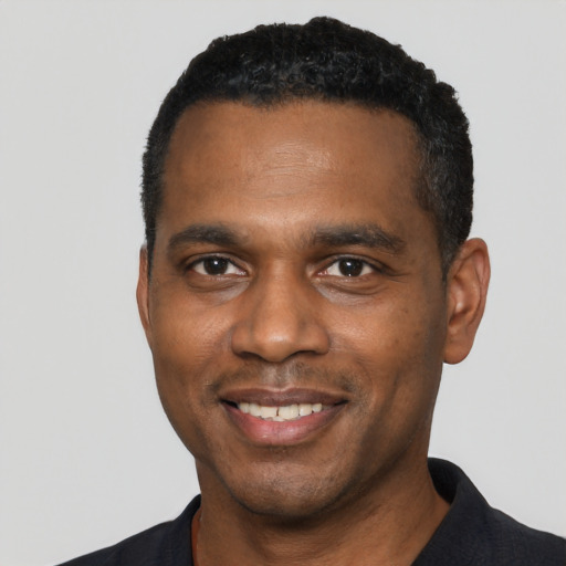 Joyful black young-adult male with short  black hair and brown eyes