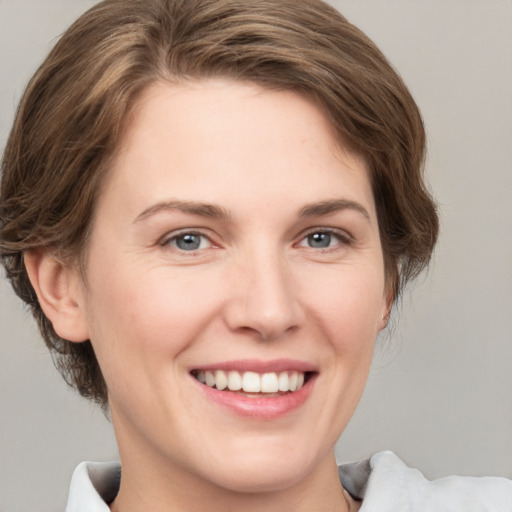 Joyful white young-adult female with medium  brown hair and grey eyes