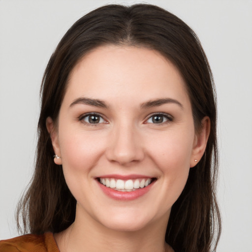 Joyful white young-adult female with long  brown hair and brown eyes