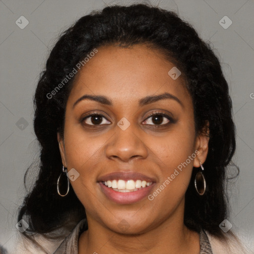 Joyful black young-adult female with long  black hair and brown eyes