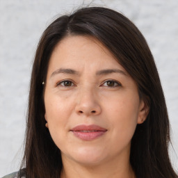 Joyful white adult female with long  brown hair and brown eyes