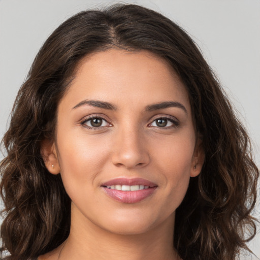 Joyful white young-adult female with long  brown hair and brown eyes