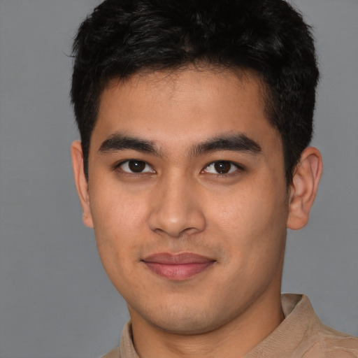 Joyful latino young-adult male with short  brown hair and brown eyes
