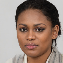 Joyful black young-adult female with long  brown hair and brown eyes