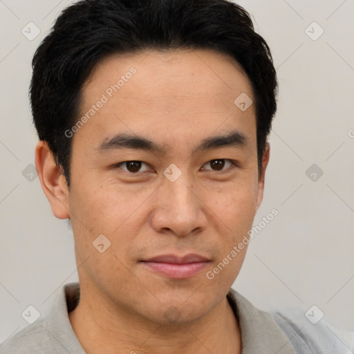 Joyful asian young-adult male with short  black hair and brown eyes