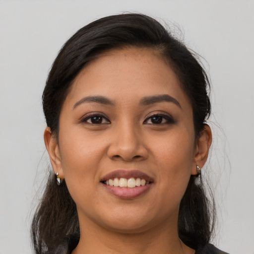 Joyful latino young-adult female with medium  brown hair and brown eyes