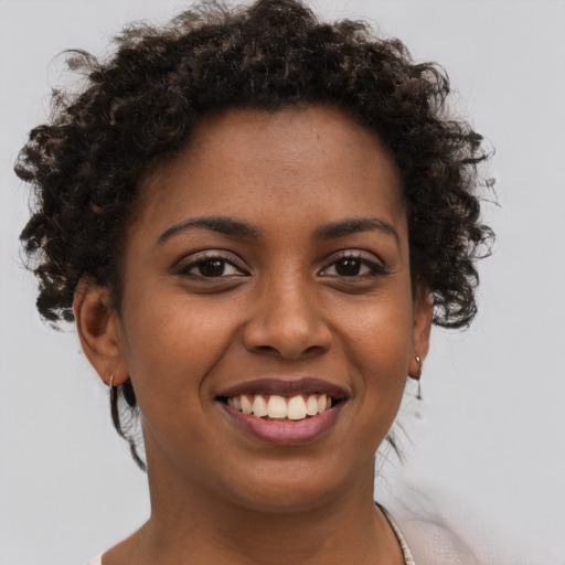 Joyful black young-adult female with short  brown hair and brown eyes