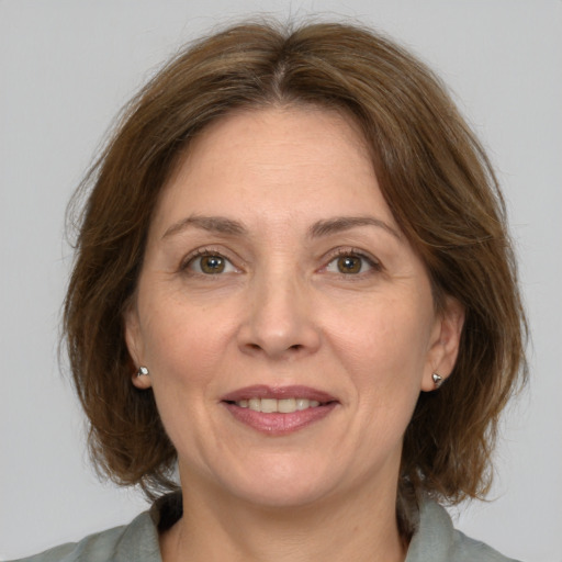 Joyful white adult female with medium  brown hair and grey eyes