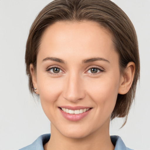 Joyful white young-adult female with medium  brown hair and grey eyes