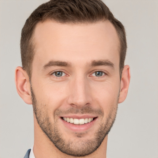 Joyful white young-adult male with short  brown hair and grey eyes