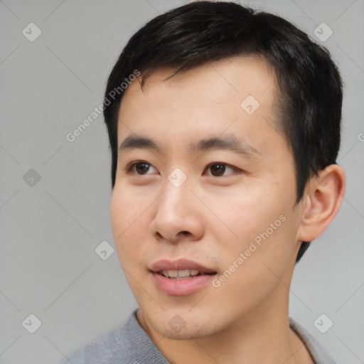 Joyful asian young-adult male with short  black hair and brown eyes