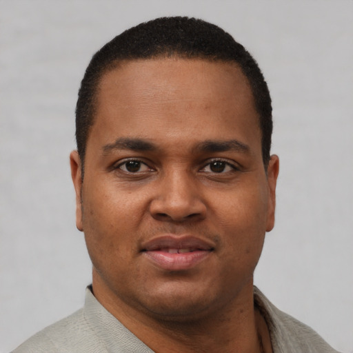 Joyful black young-adult male with short  brown hair and brown eyes