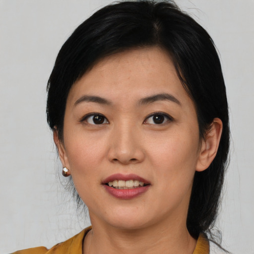 Joyful asian young-adult female with medium  black hair and brown eyes