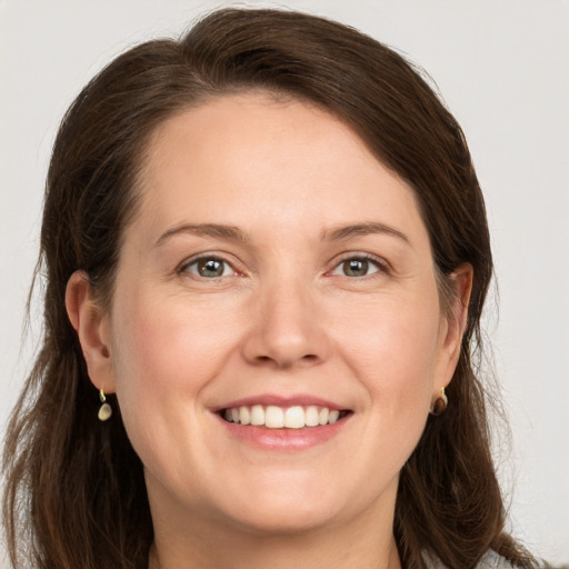 Joyful white adult female with long  brown hair and grey eyes