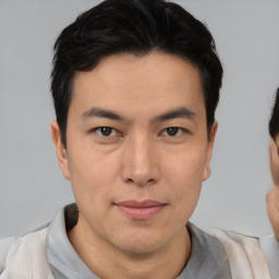 Joyful asian young-adult male with short  brown hair and brown eyes