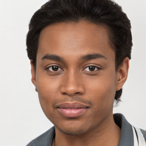 Joyful black young-adult male with short  brown hair and brown eyes