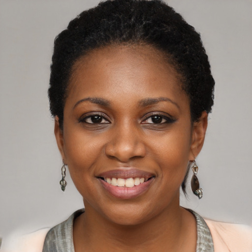 Joyful black young-adult female with long  black hair and brown eyes
