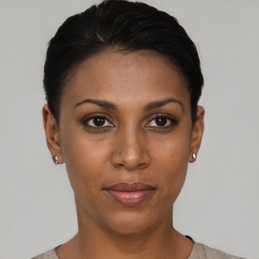 Joyful black young-adult female with short  black hair and brown eyes