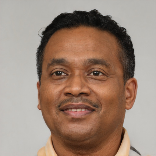 Joyful latino adult male with short  black hair and brown eyes